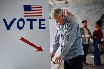 Senior man at voting booth during elections in United States of American.