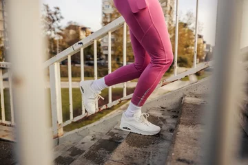 Fotobehang Female runner's legs running up the stairs in urban exterior. © dusanpetkovic1