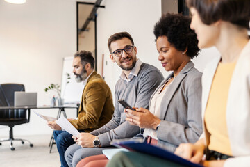 A multicultural employees sitting at corporate company and waiting for job interview.