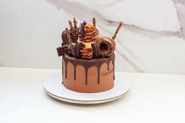 Elegant chocolate birthday cake with chocolate ganache, cupcake, popsicles, sweets, chocolate bars, waffles, donuts and cookies