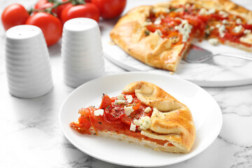 Tasty galette with tomato and cheese (Caprese galette) on white marble table, closeup