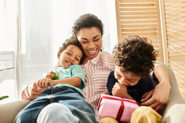 jolly african american family of three spending time together at home, present in hand, Mothers day