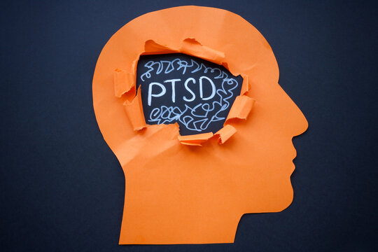Torn paper head and abbreviation PTSD Post Traumatic Stress Disorder.