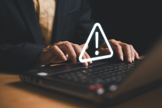 Caution failure system hacked warn alert concept. Businessman use computer laptop, triangle caution warning sign for cyber notification error, trouble maintenance. Available internet cybersecurity .