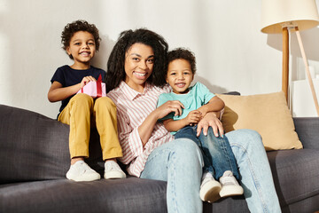 jolly african american family of three smiling joyfully at camera, present in hand, Mothers day