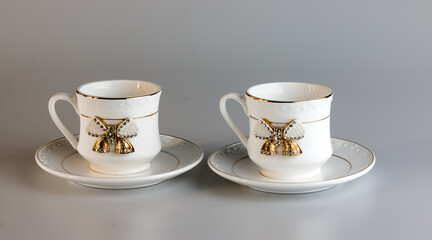Set of antique porcelain coffee cups with a bow on a white background.