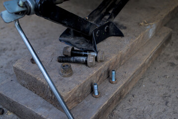 jack and wheel bolts on a wooden board
