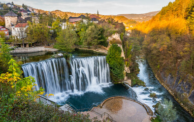 Fototapeta na wymiar Jajce town and waterfall in Bosnia and Herzegovina, Europe. Beautiful Pliva waterfall under the old town city in the autumn evening.