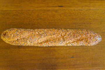 One traditional french baguette on a vintage wooden background