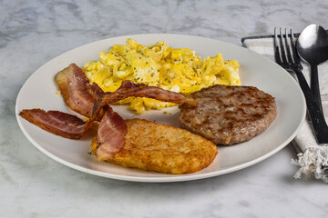 scramble eggs with sausage patty  bacon  and hash browns