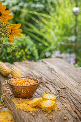 Ziarna kukurydzy w misce na drewnianym stole w ogrodzie.
