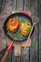 Zapiekane pomidory faszerowane polentą podane na żeliwnej czerwonej patelni. - obrazy, fototapety, plakaty
