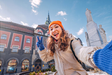 A cheerful young woman explores the charming city of Subotica, Serbia, her vibrant energy adding to...