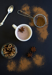 Cocoa drink in the white cup on the black background. Top view. Location vertical.