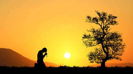 A man is kneeling and praying to God in hope.
