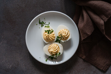 Deviled eggs with fresh herbs, perfect Easter party appetizer, directly above - 750794512