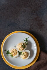Deviled eggs with fresh herbs, perfect Easter party appetizer, directly above - 750794706