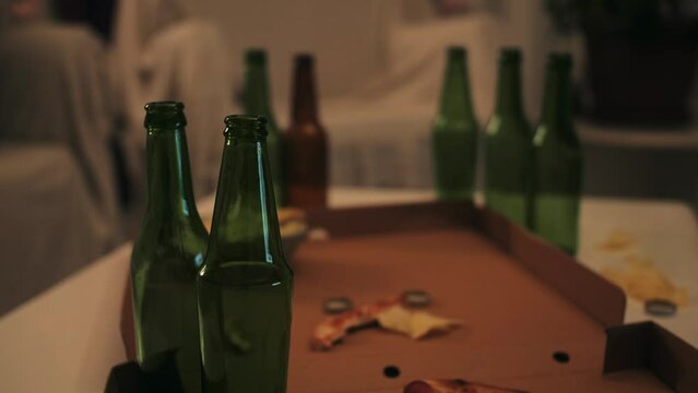 Close up of empty bottles, snack on table after party in living room.