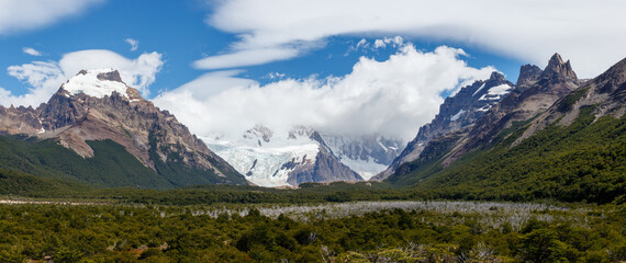 Rear view of young man in red jacket standing with open arms by laguna torre, los glaciares...