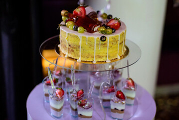 A candy bar with birthday cake and sweets for a party .