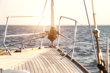 Sailing into sunset on open sea, scenery photography. View from yacht's bow sailing towards horizon...