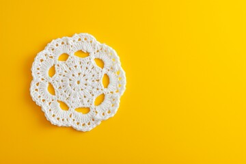 White crochet doily on a yellow background with copy space. - obrazy, fototapety, plakaty
