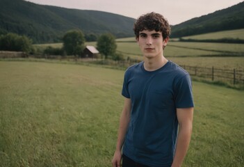 Fototapeta premium Portrait of a young male farmer, a young man, against the background of farmland