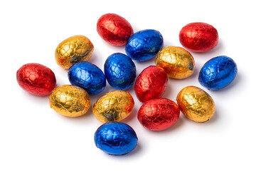 Heap of chocolate easter eggs in colorful tinfoil close up isolated on white background