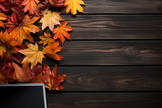 Laptop on a black wooden background with autumn leaves сreated with Generative Ai