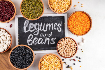Various dried  beans, lentils, mung, chickpea, pea  assortment in wooden bowls. Legumes on white...