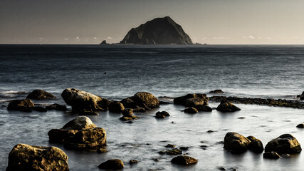 Darkened image of sunrise on a rocky coast of the geological park in Keelung, Taiwan. The contrast...