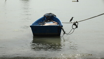 A little sampan boat tied close to a beach