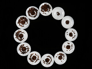 Twelve plates with coffee grains laid out in a circle like a clock   