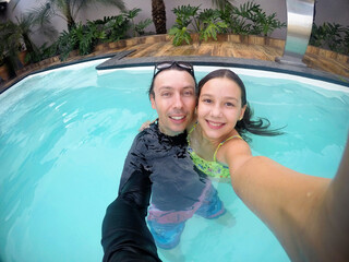 pai e filha se divertindo em água de piscina nas férias viagem de verão 