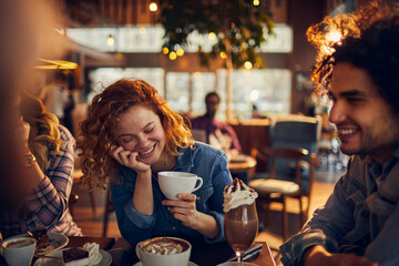Young people at a cafe enjoying coffee and talking together