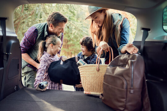 Happy family packing car for a road trip