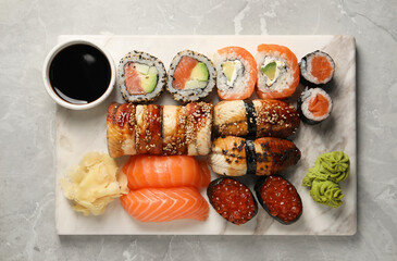 Set of tasty sushi rolls on light grey marble table, top view
