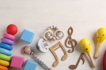 Baby song concept. Wooden notes, kids maracas and toys on table, flat lay. Space for text