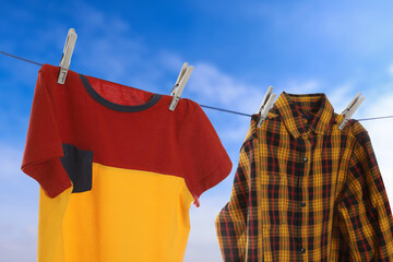 Clothes drying on washing line against blue sky