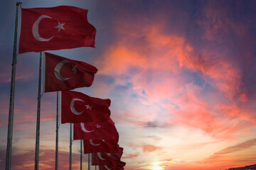 Turkish flags in a row with a sunset in the background