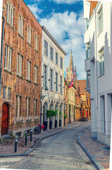 Bruges cityscape with empty narrow cobblestone street, buildings in Brugge city historical centre, Bruges old town Steenstraat quarter medieval district, vertical view, Flemish Region, Belgium