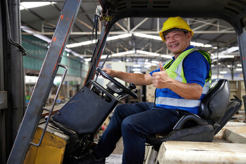 Fototapeta na wymiar senior worker driving forklift and thumbs up pose in the factory