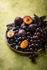 Assortment of purple fruit plum, grape, blueberry and basil