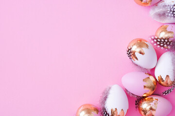 Easter eggs with golden glitter on pink background with copy space