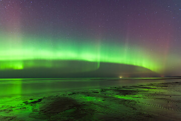 Aurora Borealis northen lights on the Baltic Sea beach in Latvia at March