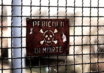 Protection fence of the dangerous area and the sign with text PERICOLO DI MORTE which means danger of death in Italian language