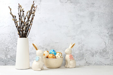Composition with decorated Easter eggs, a rabbit and willow branches in a vase. Happy Easter...