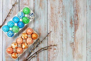 Composition with decorated Easter eggs in a box and willow branches. Happy Easter concept, banner...