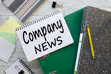 Company News text on a notebook on a green folder
