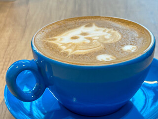 flat white. blue coffee cup. cat made from milk in a coffee-based drink. detail.